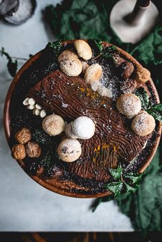 a chocolate cake with nuts and leaves on top