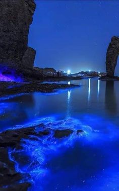 the water is very blue and it looks like it has some rocks in it with lights on them