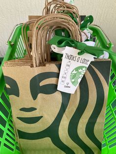 a starbucks bag with the starbucks logo on it and a green ribbon tied around it