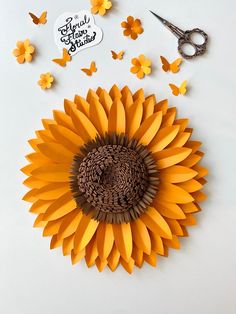 an orange paper sunflower surrounded by butterflies