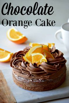 chocolate orange cake on a cutting board with sliced oranges