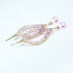 Shades of natural sparkly pink topaz have been meticulously wrapped by hand to adorn artisan 14K gold-filled leaf frames. A one of a kind original pair. M E A S U R E M E N T 2 1/2" long from top of ear wire M A T E R I A L Pink Topaz 14k gold filled metals 𝒜𝑔𝒶𝓅𝑒 𝒜𝓇𝓉𝒾𝓈𝒶𝓃 𝒥𝑒𝓌𝑒𝓁𝓇𝓎 arrives in beautiful ribbon-tied packaging, ready for gift giving. Elegant Pink Hand Wrapped Jewelry, Elegant Pink Jewelry Hand Wrapped, Elegant Hand Wrapped Pink Jewelry, Unique Pink 14k Gold Jewelry, Fine Jewelry Pink Briolette Jewelry, Unique Pink Teardrop Jewelry, Handmade Pink 14k Gold Jewelry, Handmade 14k Gold Pink Jewelry, Pink Faceted Amethyst Jewelry