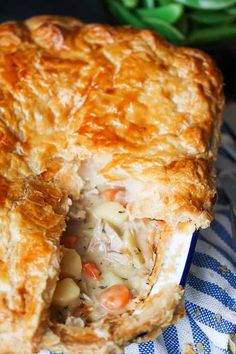 a chicken pot pie is cut in half on a blue and white checkered napkin