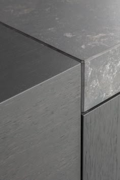 a close up view of the top of a grey cabinet with wood grained edges