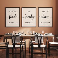 the dining room table is set with four chairs and two framed prints on the wall