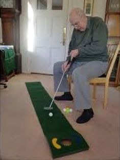 an older man playing mini golf in his living room