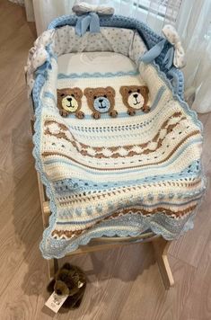 a crocheted teddy bear blanket sitting on top of a baby bassinet