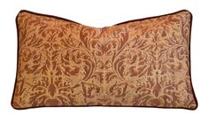 an orange and brown decorative pillow on a white background