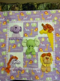 a baby quilt with stuffed animals on it's sides and purple squares around the edges