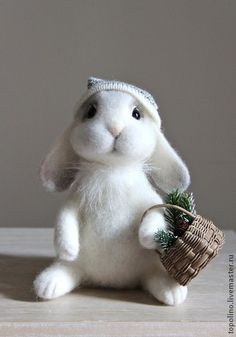 a white stuffed rabbit holding a basket with a pine cone in it's mouth