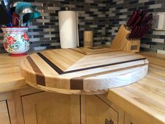 a wooden cutting board sitting on top of a kitchen counter next to a knife holder