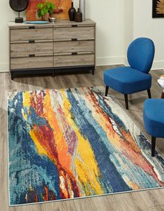 a living room with blue chairs and a colorful rug