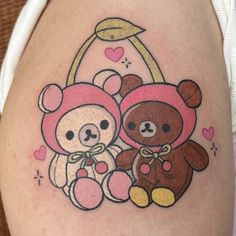 two teddy bears sitting next to each other on the side of a woman's thigh