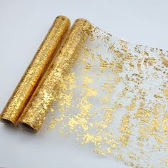 two rolled up gold glitter paper on top of each other