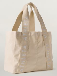 Athleta Logo Tote Bag | Athleta Canvas Bags With Logo Strap For Travel, Canvas Travel Bag With Logo Strap, Travel Canvas Bag With Logo Strap, Everyday White Shoulder Bag With Logo Strap, White Shoulder Bag With Logo Strap For Everyday, Daily Use Tote Bag With Logo Strap, Everyday Bags With Logo Strap, Beige Travel Bag With Logo Strap, Canvas Tote Bag Outfit