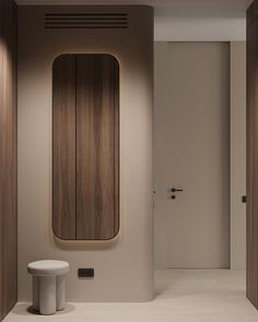 a white toilet sitting next to a wooden mirror on the wall in a room with wood paneling