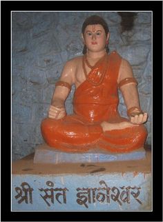 a buddha statue sitting on top of a blue block