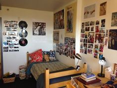 a bed room with a neatly made bed and lots of pictures on the wall