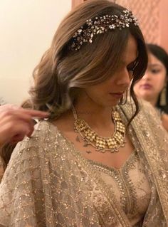 a woman is getting her hair done in a bridal dress and wearing a tiara