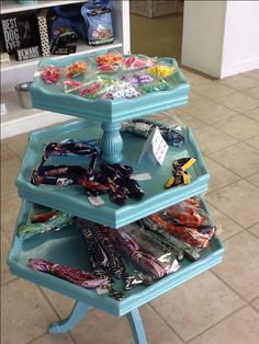 three tiered tray with various items on it in the middle of a tile floor