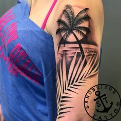 a woman's arm with a palm tree tattoo on it