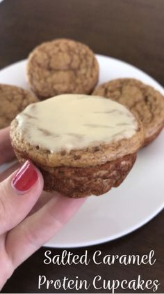 someone is holding up some cookies with icing on them and the words salted caramel protein cupcakes