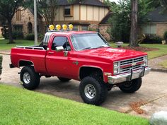 a red pick up truck parked in front of a house