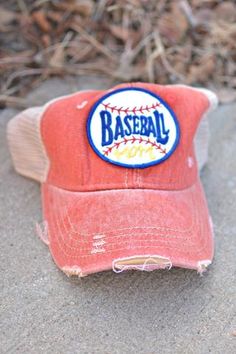 a baseball cap with the word baseball on it sitting in front of some grass and dirt