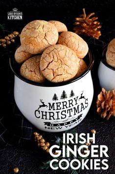 some cookies are in a white bowl on a black table with pine cones and decorations