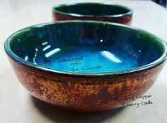 two brown and blue bowls sitting on top of a table