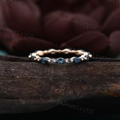 a gold ring with blue sapphire stones on top of a tree branch in front of a brown background