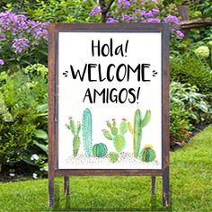 a wedding sign in the grass with cactus and flowers behind it, which reads,