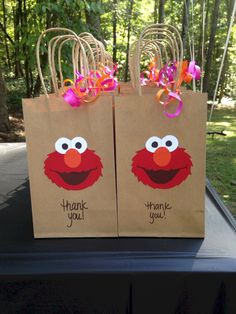 two brown bags with sesame street characters on them and thank you written on the bags