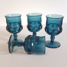 three blue glass goblets sitting next to each other