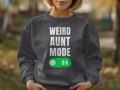 Featuring a cool funny phrase Weird aunt mode on with white text and an on button. Great for aunt appreciation day Great for aunts or aunties. Get this for aunts to be or new aunts. Gildan 18000 ▶Unisex Adult Sizing ▶See Our Size Chart For Proper Sizing ✈ PROCESSING & SHIPPING ✈ Processing Time: 1-5 Business days. (usually 1-3 days but please allow for extra time during holiday seasons) Standard Shipping: 2-5 business days after processing time Returns & Exchanges We have a no return and exchange policy due to the made to order nature of our items. Please contact us if you have any issues. CARE INSTRUCTIONS  - Turn shirt inside out - Machine wash gentle cycle: cold water - Place in dryer on low temperature The Gildan 18000 Unisex Heavy Blend™ Crewneck Sweatshirt is perfect for any occasion Funny Winter Top With Text, Winter Funny Style Top With Text, Winter Funny Text Top, Funny Long Sleeve Tops With Text, New Aunt, Funny Phrases, Aunt Gifts, Funny Sweatshirts, Boys Hoodies