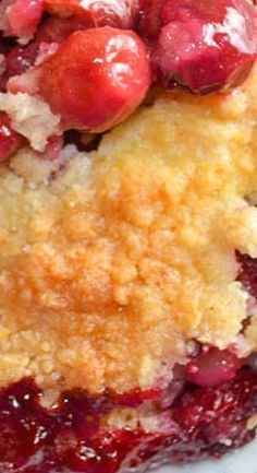 a close up of a piece of cake on a white plate with cherries and crumbs