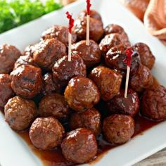 meatballs with sauce and toothpicks on a white plate