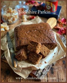 a loaf of chocolate cake sitting on top of a wooden table next to a knife