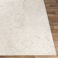 a large white rug on top of a wooden floor