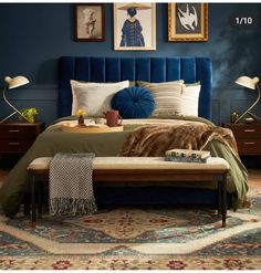 a bedroom with blue walls and pictures on the wall above the bed, along with an upholstered bench