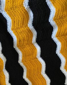 a black, yellow and white crocheted afghan