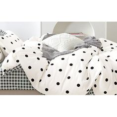 an unmade bed with black and white polka dots