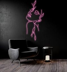 a room with a chair, table and neon pink wall decal on the wall