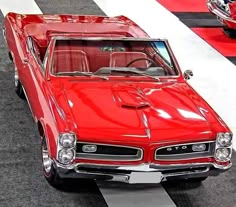 an old red car is on display in a showroom