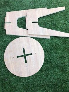 two pieces of wood cut out to look like scissors and a disc on the grass