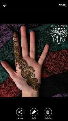 someones hand with henna on it that is showing the intricate pattern and design