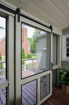 an open door on the outside of a house with wood flooring and white walls