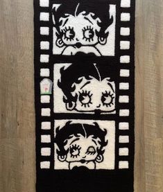 a black and white rug with two pictures of dogs on the front, one has been made to look like film strips