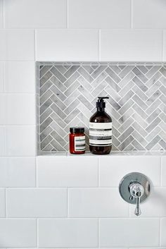 a bathroom with white tile and gray grout