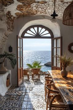 an open door leading to the ocean with chairs and tables in front of it on tiled flooring